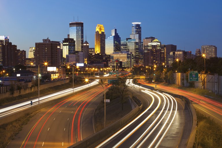 Image of Minneapolis skyline and highway with traffic lines leading to the city.