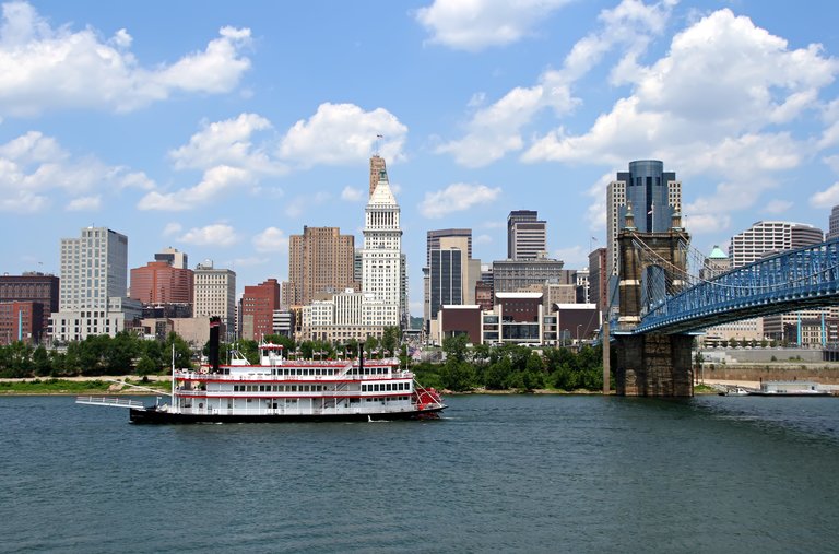 Replica steamboat travels down the Ohio River in front of the Cincinnati skyline.