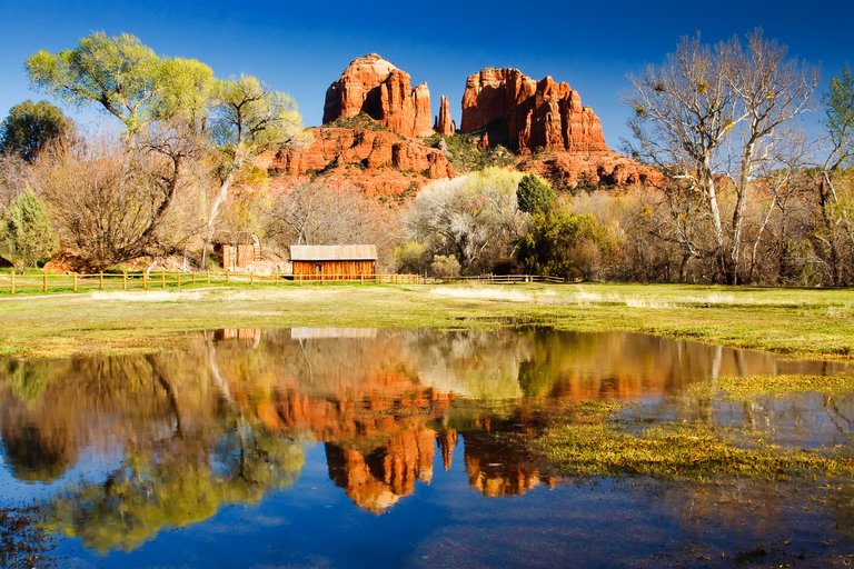 The view of Cathedral Rock in Sedona, Arizona. The towering rock formations stand out like beacons in the dimmed landscape of the Red Rock State Park.
