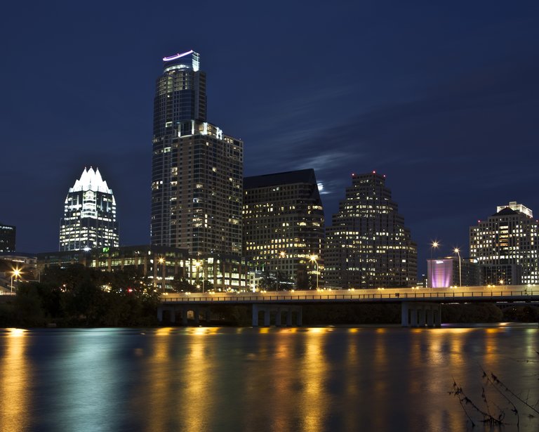 Night view of the Austin, Texas skyline with colored light reflections in water